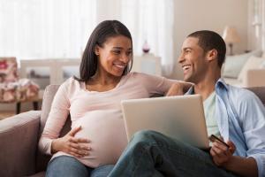 Pregnant woman smiling at her partner on the couch